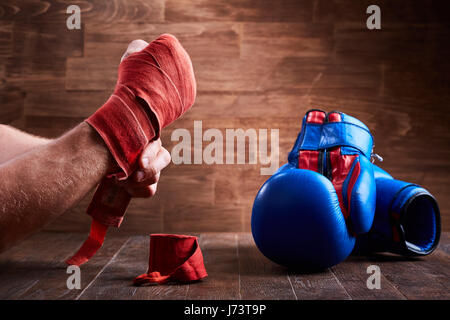 Close-up of the hands of a young boxer who winds boxing bandages and gloves. Stock Photo