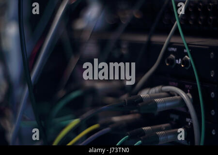 Recording studio gears in rack. Audio cables and connectors in studio equipment. Selective focus. Stock Photo