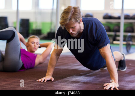 man exercising and doing straight arm plank in gym Stock Photo