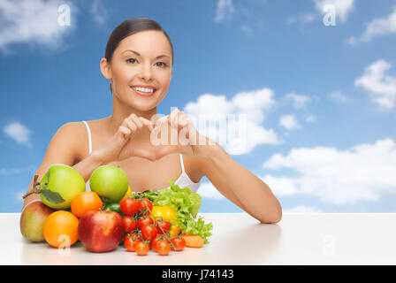 woman with fruits and vegetables showing heart Stock Photo