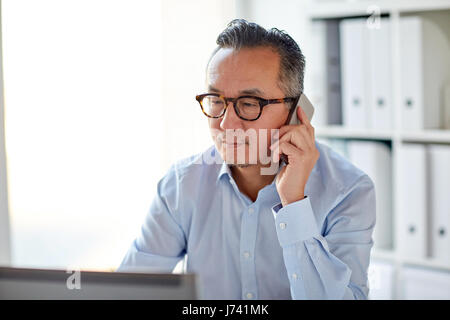 businessman with laptop calling on smartphone Stock Photo