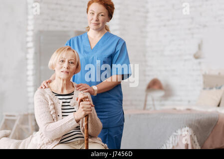 Qualified private nurse assisting elderly patient Stock Photo