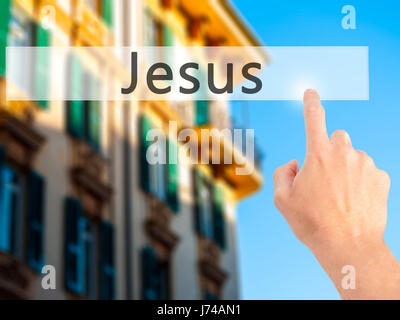 Jesus - Hand pressing a button on blurred background concept . Business, technology, internet concept. Stock Photo Stock Photo