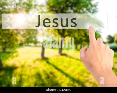 Jesus - Hand pressing a button on blurred background concept . Business, technology, internet concept. Stock Photo Stock Photo