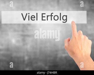 Viel Erfolg  (Much Success In German) - Hand pressing a button on blurred background concept . Business, technology, internet concept. Stock Photo Stock Photo