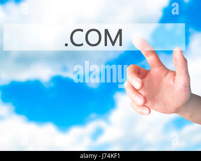 .COM - Hand pressing a button on blurred background concept . Business, technology, internet concept. Stock Photo Stock Photo