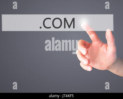 .COM - Hand pressing a button on blurred background concept . Business, technology, internet concept. Stock Photo Stock Photo