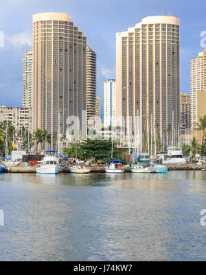 Honolulu, Hawaii, USA - May 30, 2016: Yachts docked at Ala Wai Boat Harbor in the Kahanamoku Lagoon against cityscape of Ala Moana. Stock Photo