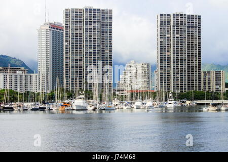 Honolulu, Hawaii, USA - May 30, 2016: Yachts docked at Ala Wai Boat Harbor in the Kahanamoku Lagoon against cityscape of Ala Moana. Stock Photo