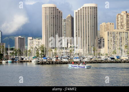 Honolulu, Hawaii, USA - May 30, 2016: Yachts docked at Ala Wai Boat Harbor in the Kahanamoku Lagoon against cityscape of Ala Moana. Stock Photo