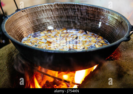 Vegetables being fried over a wood fired stove made out of mud and clay in a traditional outdoor Sri Lankan kitchen. Stock Photo