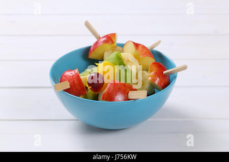 fresh fruit skewers in turquoise bowl Stock Photo