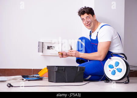 Funny Man doing electrical repairs at home Stock Photo