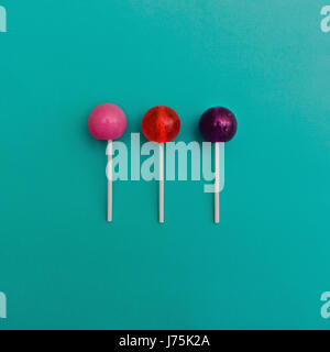Lollipop Flat lay Minimal concept Three colorful round lollipops are lying on a light blue background Stock Photo