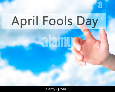 April Fools Day - Hand pressing a button on blurred background concept . Business, technology, internet concept. Stock Photo Stock Photo