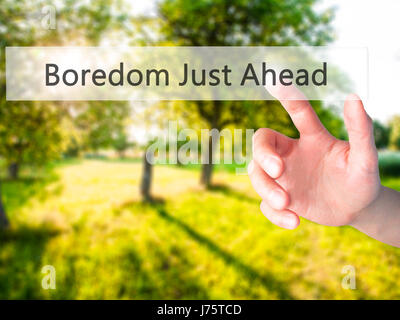 Boredom Just Ahead - Hand pressing a button on blurred background concept . Business, technology, internet concept. Stock Photo Stock Photo