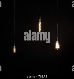 Bright glowing light bulbs of different shapes on the dark background Stock Photo