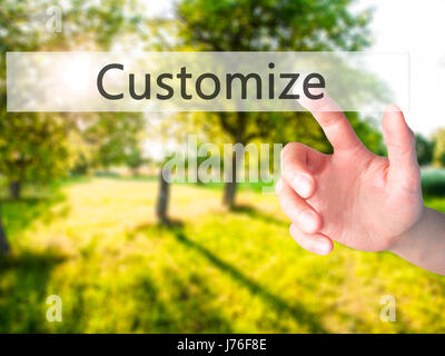 Customize - Hand pressing a button on blurred background concept . Business, technology, internet concept. Stock Photo Stock Photo