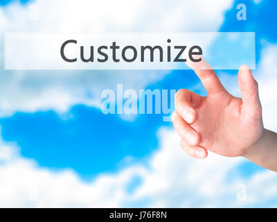 Customize - Hand pressing a button on blurred background concept . Business, technology, internet concept. Stock Photo Stock Photo