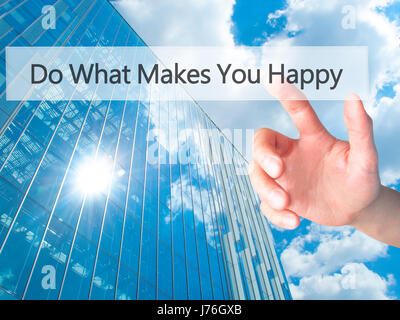 Do What Makes You Happy - Hand pressing a button on blurred background concept . Business, technology, internet concept. Stock Photo Stock Photo