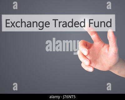 Exchange Traded Fund - Hand pressing a button on blurred background concept . Business, technology, internet concept. Stock Photo Stock Photo