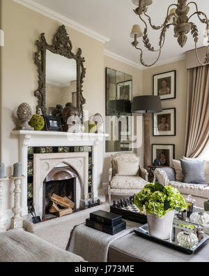Drawing room with ottoman, chandelier and three-seater linen sofa all from Bardoe & Appel. The walls are painted in Oxford Stone estate by Farrow & Ba Stock Photo