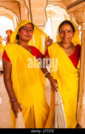 Two female Cleaning Ladies at the Amber Fort in Jaipur,India,in yellow dresses Stock Photo