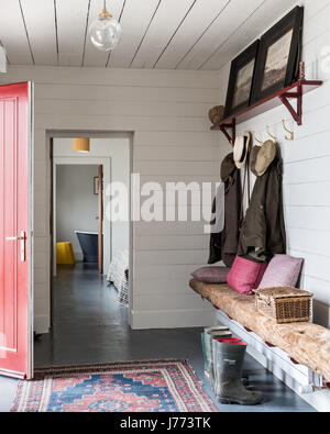 Jackets and hats hang in hallway of renovated 17th century stone cottage in Kintyre, Scotland Stock Photo