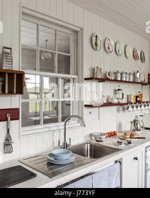 Kitchenware on shelves with stainless steel sink in 17th century Kintyre stone cottage Stock Photo