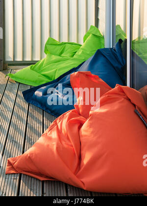 Brightly coloured bean bags on the wooden balcony Stock Photo