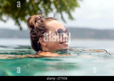 Smiling woman wearing sunglasses swimming in sea Stock Photo