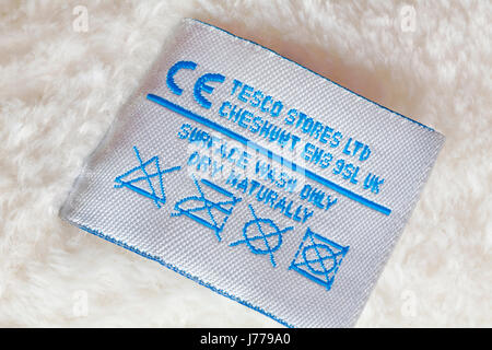 Information on label - surface wash only dry naturally label in teddy bear by Tesco Stores Ltd showing care and washing instructions Stock Photo