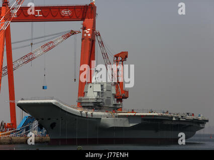 Dalian, LIAONING, CHINA. 6th May, 2017. China's first domestically built aircraft carrier, officially launched last month, remains parked in the shipyard where it was built in the port city Dalian, one of China's major ports, in Liaoning Province on May 6, 2017. The carrier is not ready for operation, but it was hailed as a naval milestone in President Xi Jinping's drive to extend China's military reach far beyond its shores. Credit: Stephen Shaver/ZUMA Wire/Alamy Live News Stock Photo