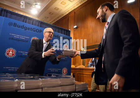 Washington, DC, USA. 23rd May, 2017. Eric Ueland (L), Republican staff director at Senate Budget Committee hands out copies of President Donald Trump's fiscal 2018 federal budget to congressional staffers on Capitol Hill in Washington, DC, May 23, 2017. The Trump administration on Tuesday unveiled its first full budget that would cut 3.6 trillion U.S. dollars in government spending over the next 10 years to balance the federal budget. Credit: Yin Bogu/Xinhua/Alamy Live News Stock Photo