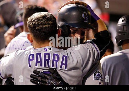 Colorado Rockies' Charlie Blackmon, left, shows to trainer Scott Gehret  where a foul ball hit his batting helmet as he stood in the on-deck circle,  during the third inning of the team's