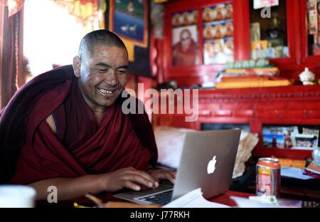 (170524) -- LHASA, May 24, 2017 (Xinhua) -- Lama Ngawang Peljor practices typing at the Rongpu Monastery near Mount Qomolangma in southwest China's Tibet Autonomous Region, May 17, 2017. Rongpu Monastery, the world's highest monastery at the altitude of over 5,000 meters, located at the foot of Mount Qomolangma in Tingri County. The 36-year-old Ngawang Peljor has practiced Buddhism in the monastery for 15 years. He lives a simple and regular monastic life here. Getting up at 8:30 a.m., he chants after breakfast till noon. He keeps chanting till 4 p.m. after one-hour break for lunch. After dinn Stock Photo