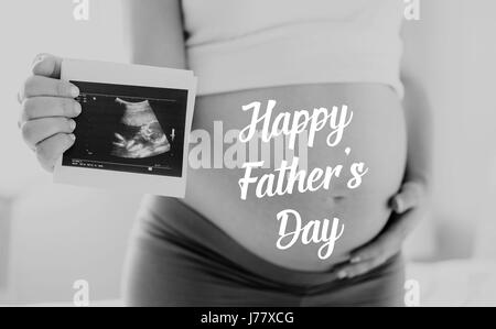 Pregnant woman holding ultrasound photo. Fathers day. Stock Photo