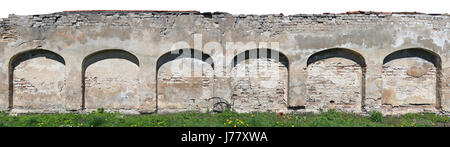 Long fragment of the destroyed ruined arch wall fence from clay bricks and plaster. Isolated from top panoramic collage from several photos. Sunny spr Stock Photo