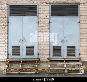 Two gray vintage  locked metal gates to electric transformer boxes Stock Photo
