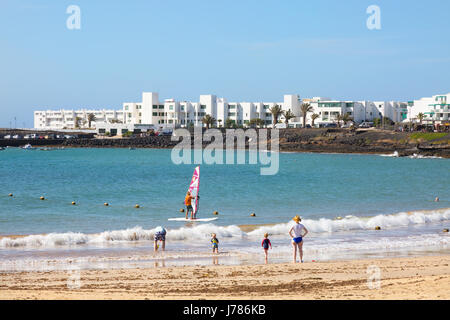 A family on holiday; Las Cucharas Beach, Playa Bastian, Costa Teguise, Lanzarote, Canary Islands Stock Photo