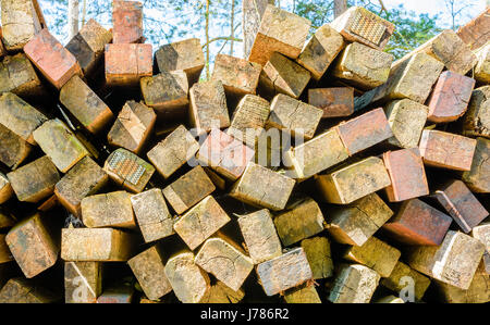 Large stack of used railway ties on storage area in woodland environment. Here seen from the side in closeup. Stock Photo