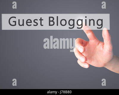 Guest Blogging - Hand pressing a button on blurred background concept . Business, technology, internet concept. Stock Photo Stock Photo