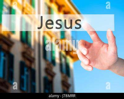 Jesus - Hand pressing a button on blurred background concept . Business, technology, internet concept. Stock Photo Stock Photo