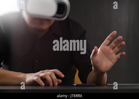 businessman wearing virtual reality goggles in modern office with Smartphone using with VR headset Stock Photo
