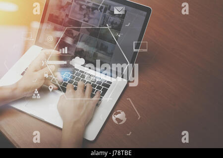 top view of Hand using credit card and laptop computer on wooden desk with VR icon chart graph diagram Stock Photo