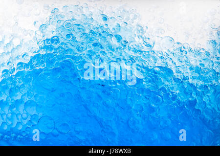 The macro picture shows underwater bubbles which raise from blue water Stock Photo