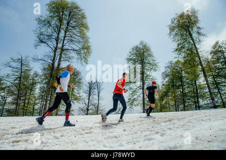 three men runners running snowy mountain trail in race Vertical kilometer Stock Photo