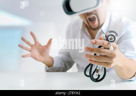 smart doctor wearing virtual reality goggles in modern office with mobile phone using with VR headset Stock Photo