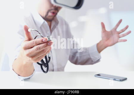 smart doctor wearing virtual reality goggles in modern office with mobile phone using with VR headset Stock Photo