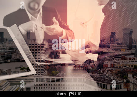 co working team meeting concept,businessman using smart phone and digital tablet and laptop computer in modern office with London city exposure Stock Photo